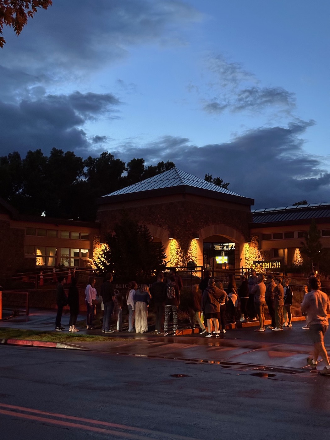 Visitors photographing the Flagstaff City Library on a dark evening