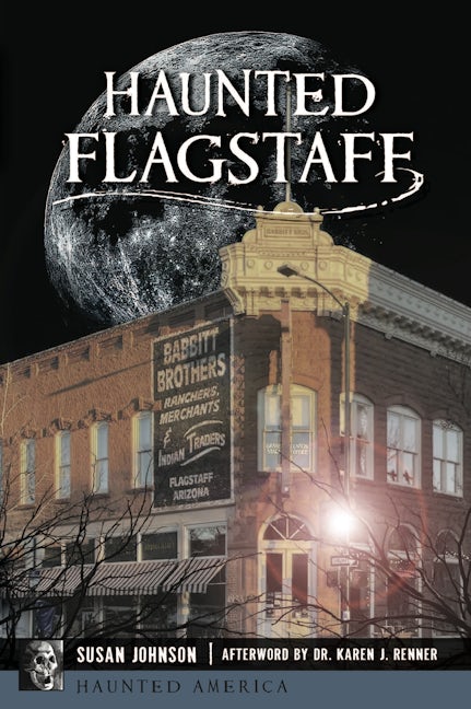 Haunted Flagstaff book cover: a full moon rising behind the Babbitt Brothers building ghost sign