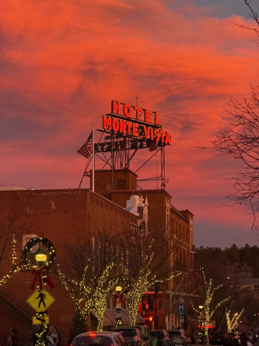 The Hotel Monte Vista neon sign glowing over downtown Flagstaff at sunset